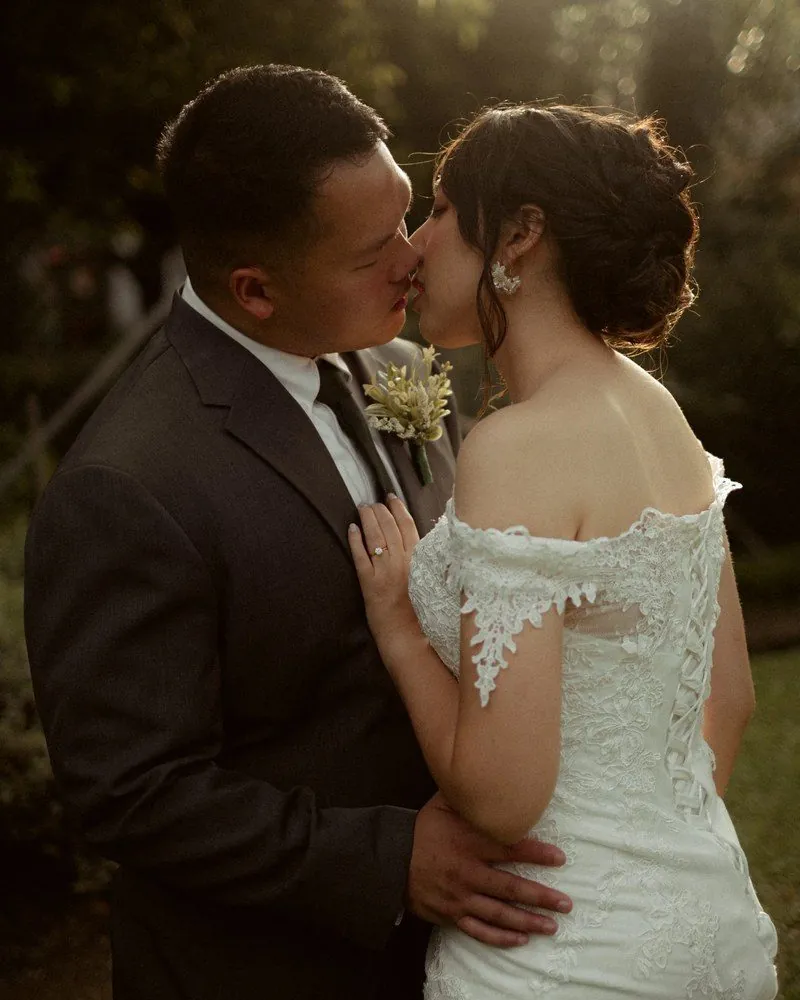 Bride and groom sharing a kiss in golden evening light