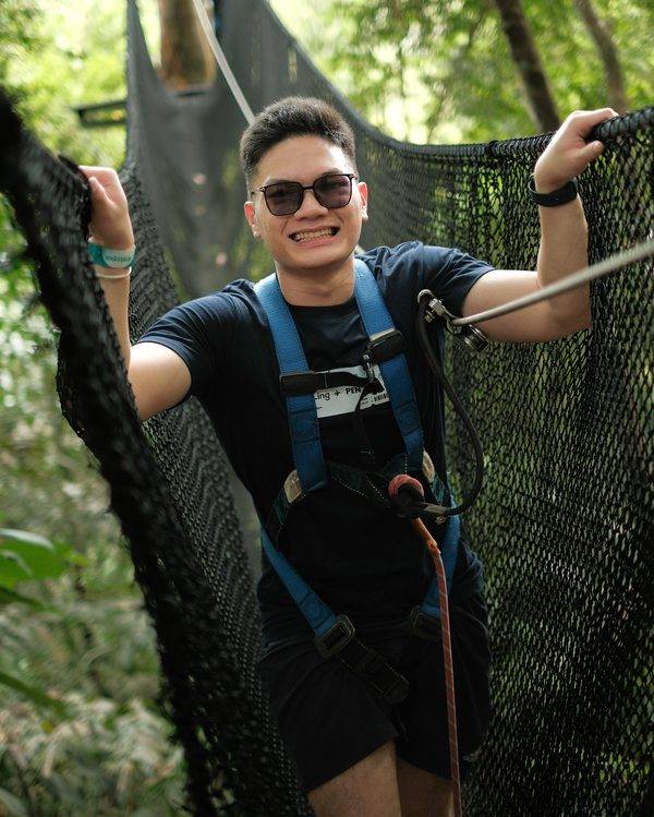 Event photographer in Penang capturing a guest smiling on a treetop canopy walk adventure