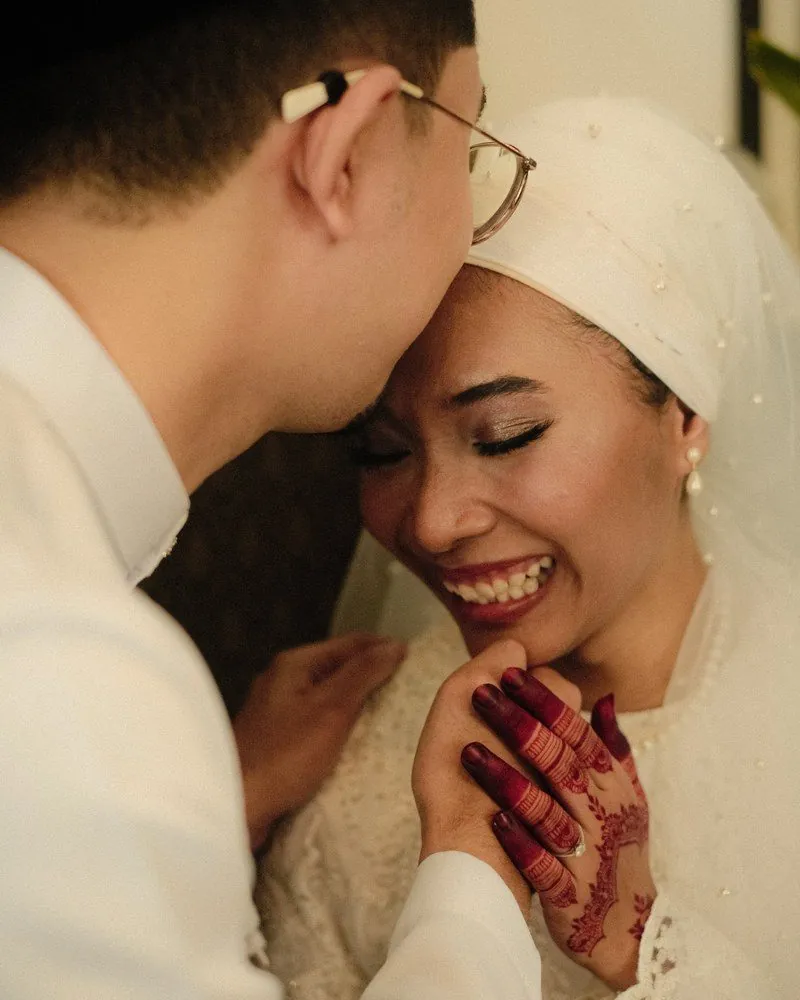 Groom kissing his bride on the forehead after their akad nikah