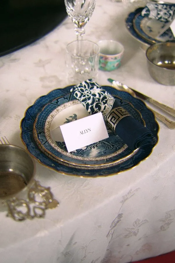 Wedding place card on blue-and-white porcelain plates with a silver napkin ring